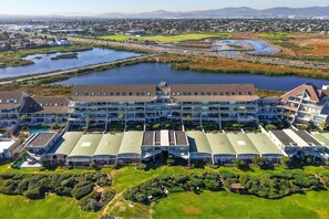 A large hotel with multiple buildings, a central courtyard, and a view of a lake and surrounding landscape.