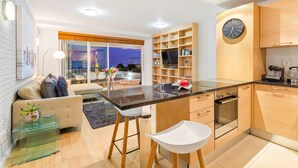 Una cocina moderna con una isla central, armarios de madera y un horno empotrado.