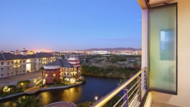 Blick vom Balkon auf einen Fluss mit Gebäuden und einer Brücke.