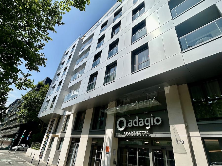 A modern building with a sign for 'Adagio Apartments'.