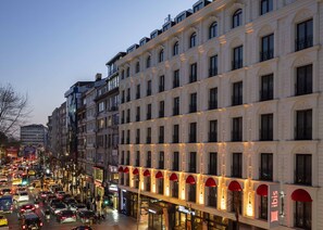 A multi-story building with a row of shops on the ground floor, including a visible coffee shop. - ibis Istanbul Sisli (Istanbul)