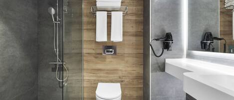 A modern bathroom with a glass-enclosed shower, a white toilet, and a wooden accent wall.