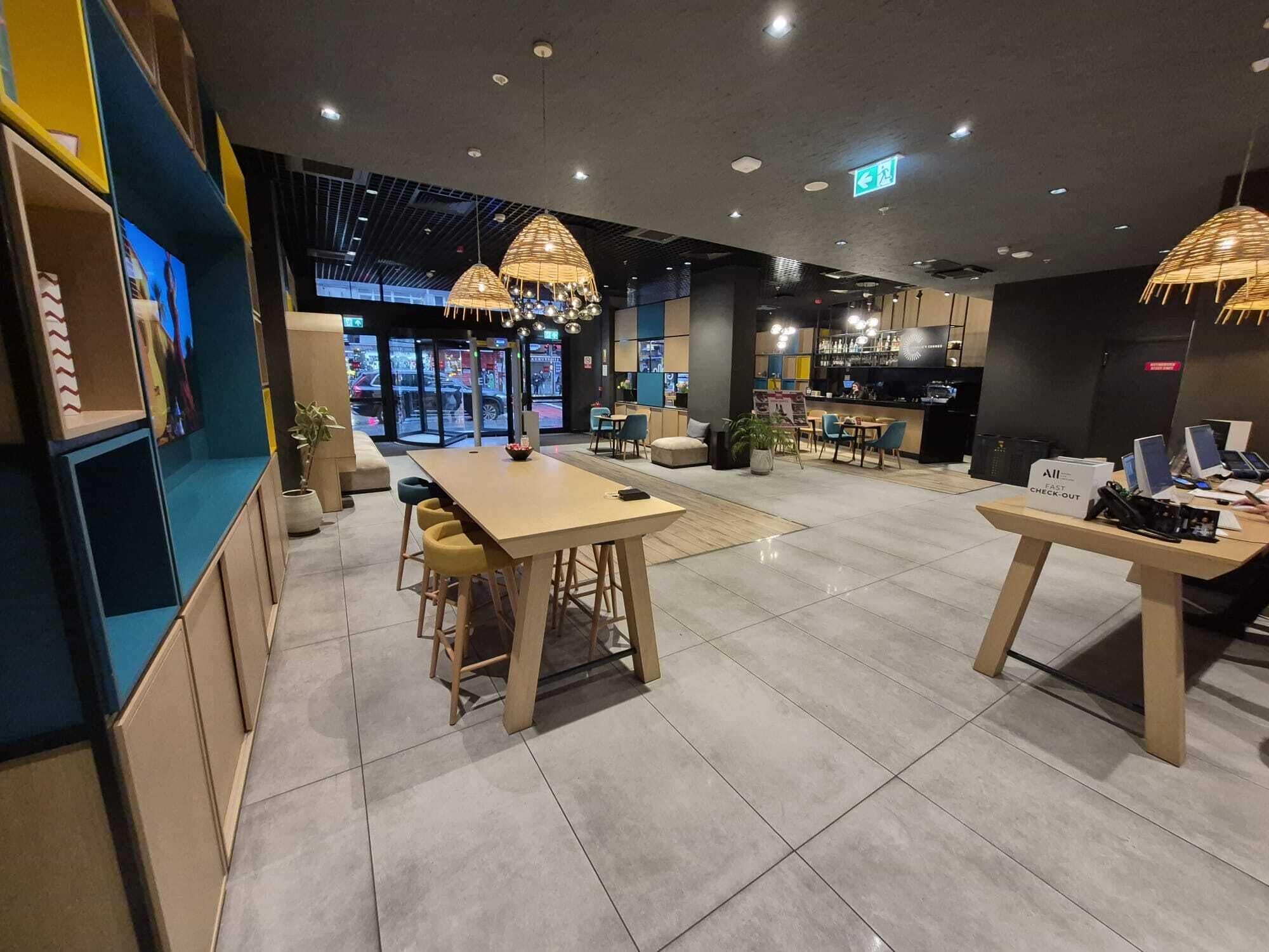 A modern interior with a central dining area, a bar, and a checkout counter.