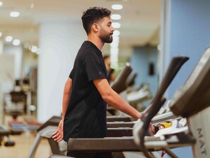 Uma academia com esteiras e equipamentos de ginástica.