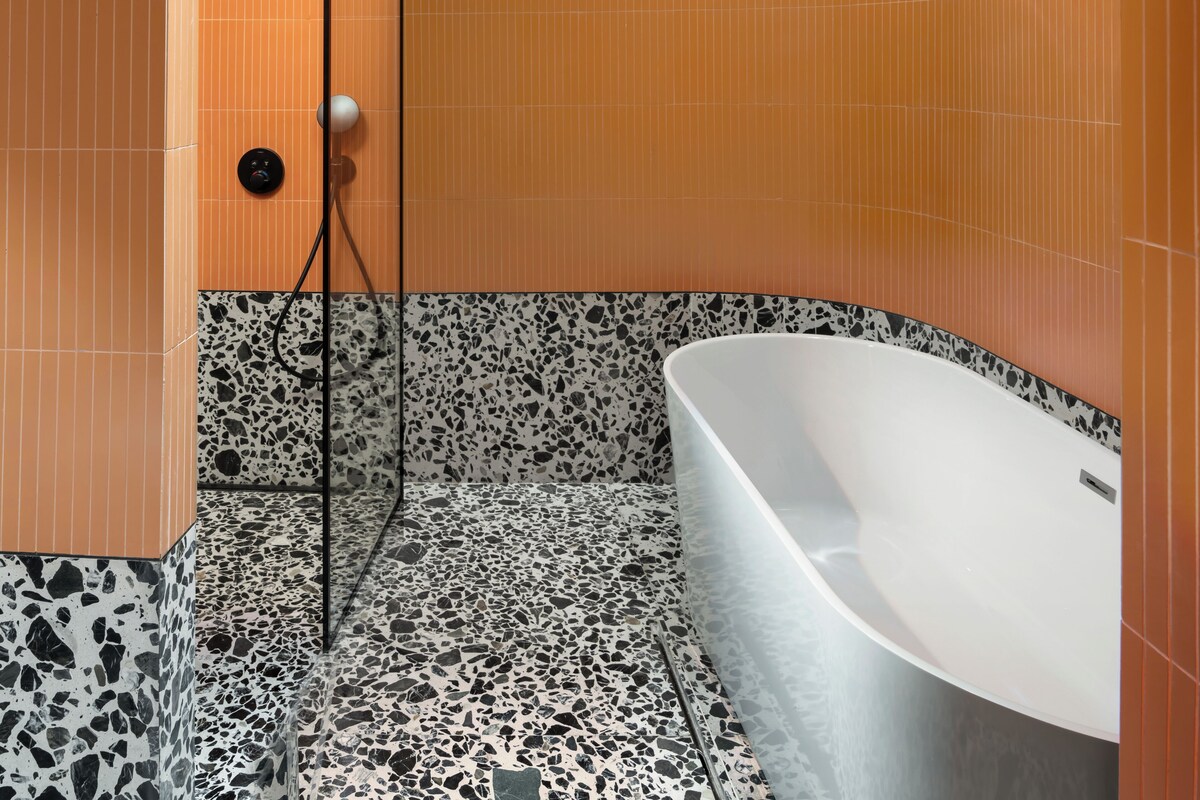 Un baño moderno con una bañera independiente, ducha y panel de control.