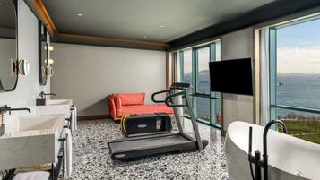 Un bagno moderno con una vasca da bagno grande, un tapis roulant e un divano.