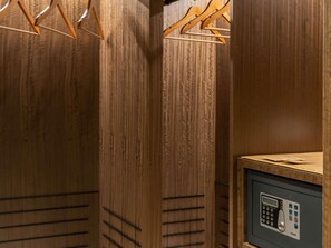 A wooden wardrobe with a built-in safe, a hanging rack, and a control panel. - Mövenpick Hotel Istanbul Marmara Sea (Istanbul)