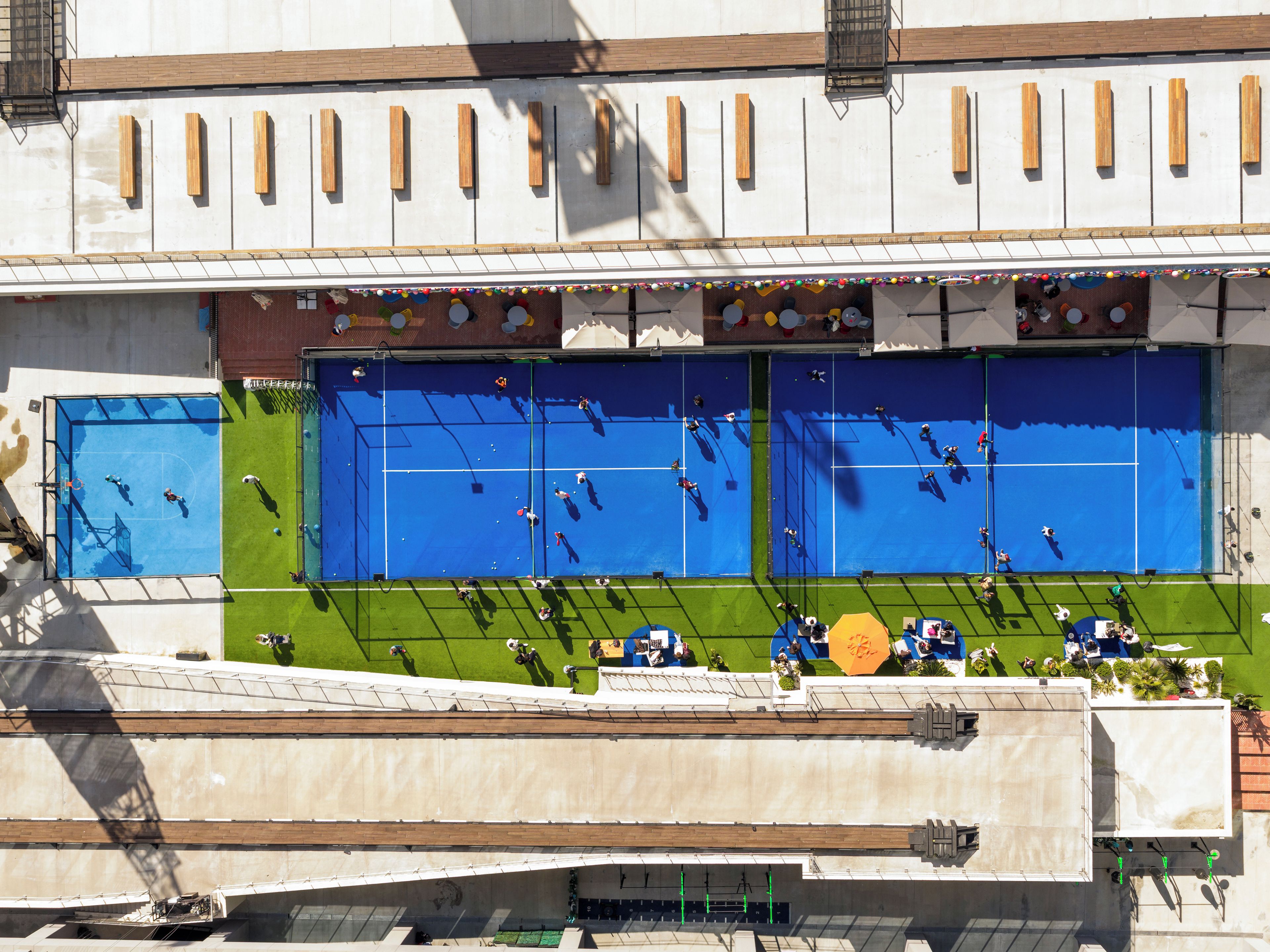 A multi-level sports facility with multiple courts, including tennis and basketball.