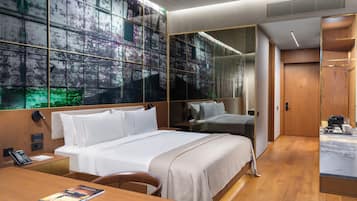 Una habitación de hotel moderna con una cama grande, mesitas de noche, un escritorio y un armario.