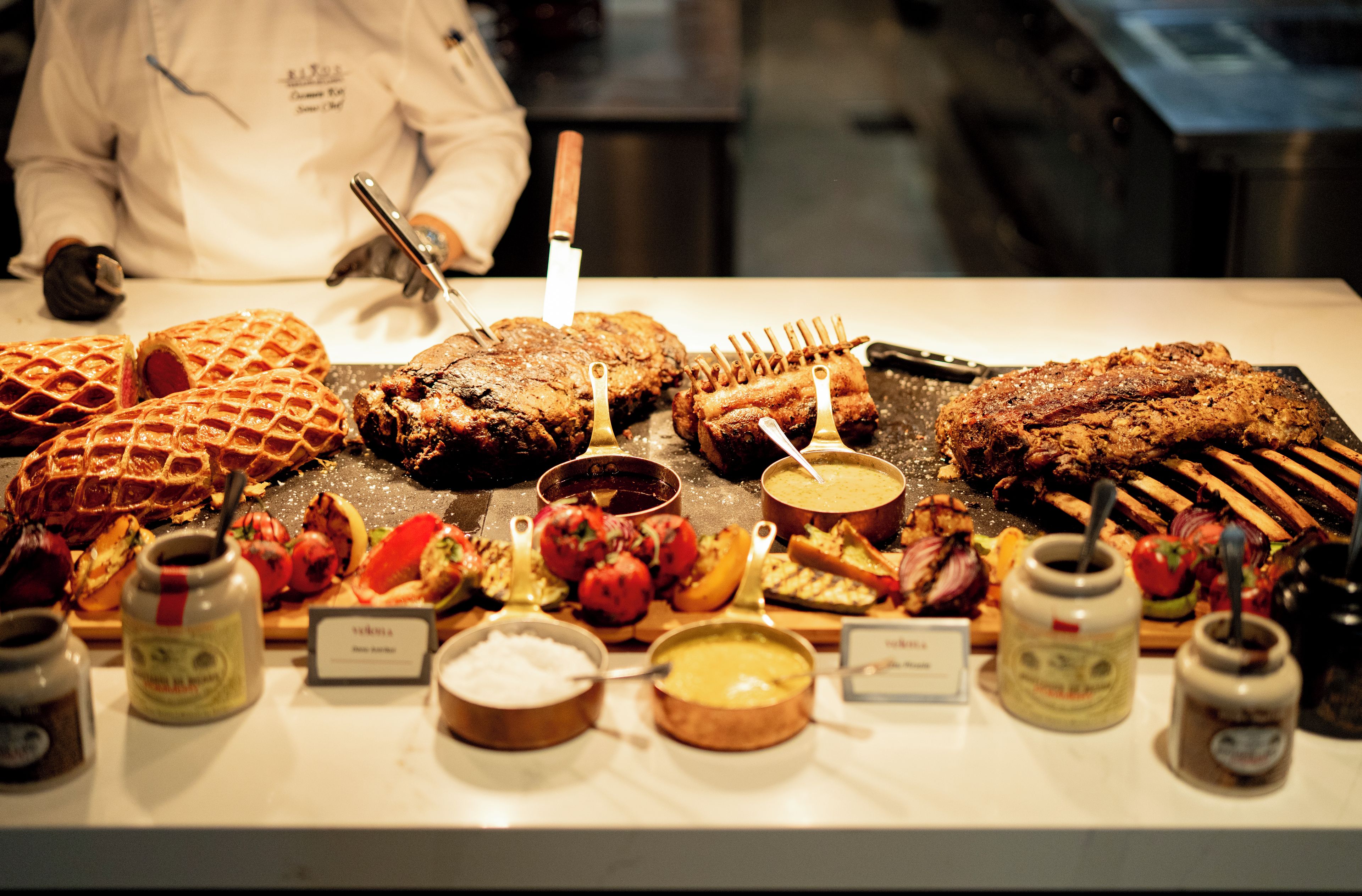 A buffet with various dishes including waffles, meats, and vegetables.