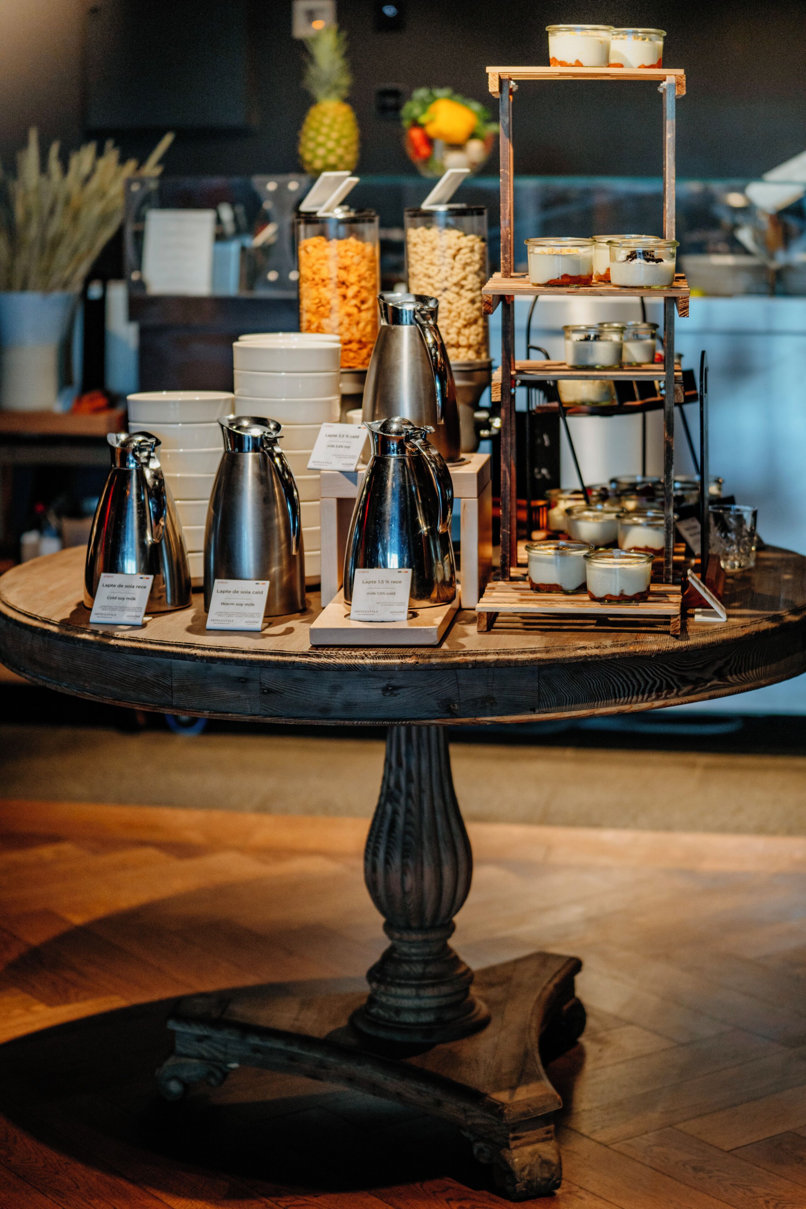 Una estación de café con diferentes máquinas de café y un expositor escalonado de alimentos.