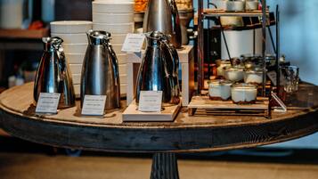 Una estación de café con diferentes máquinas de café y un expositor escalonado de alimentos.