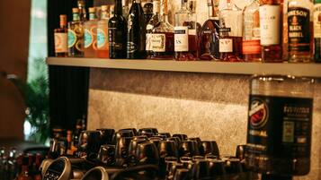 Un espace bar avec des étagères remplies de bouteilles d’alcool et une collection de verres.