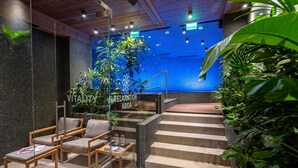 Uma área de relaxamento moderna com assentos, um espelho d'água e uma escadaria.