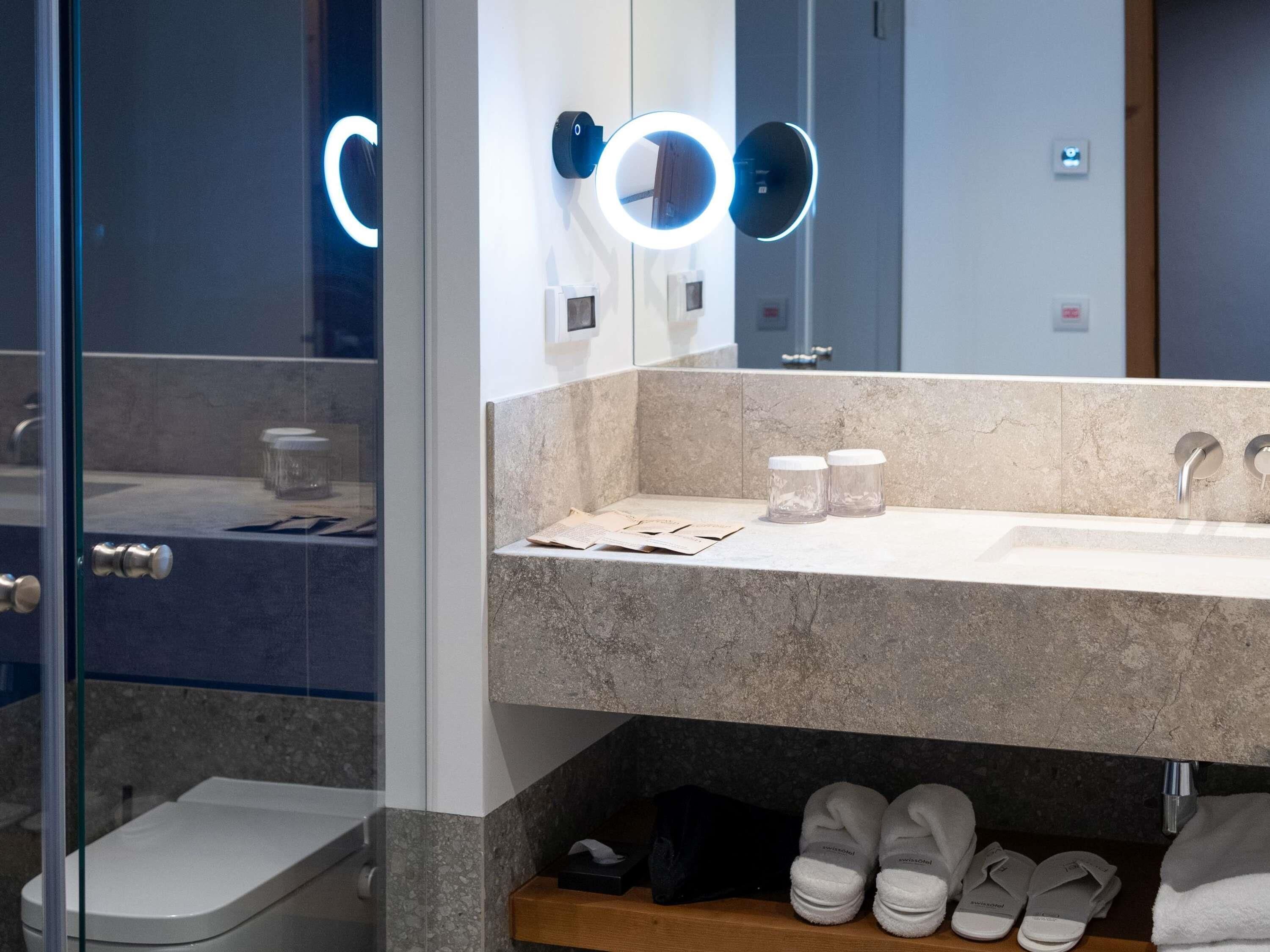Un baño con lavabo, espejo y perchero.