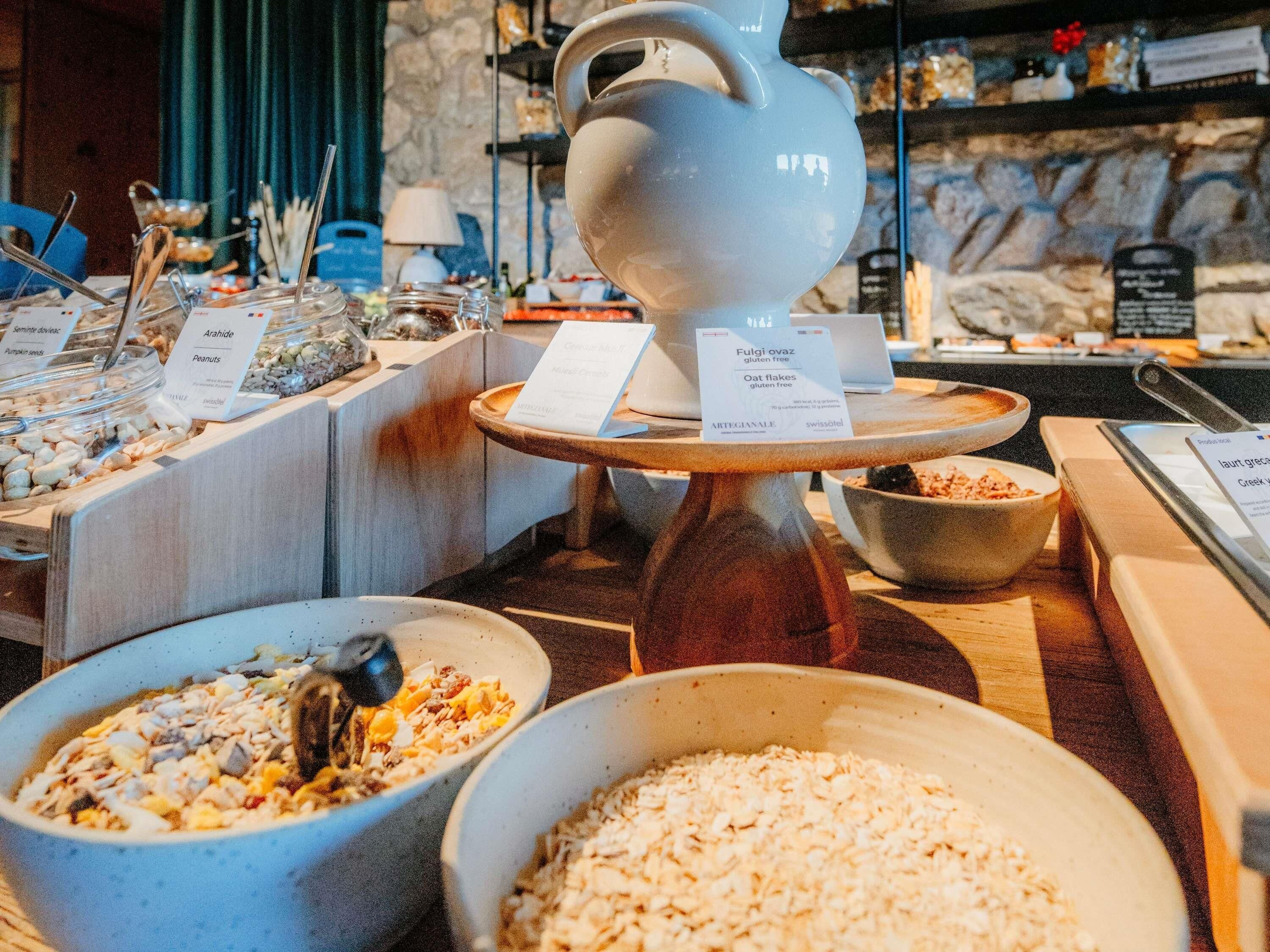 A buffet with various food options including oatmeal, nuts, and gluten-free oat flakes.