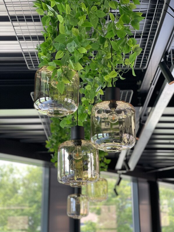 Un interior moderno con lámparas colgantes de vidrio y una planta verde.