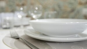 A white dining table with a bowl, a fork, and a knife.