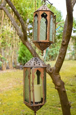 A metal lantern with a candle inside, hanging from a tree branch. - Maxim Suite in Corfu (Corfu)