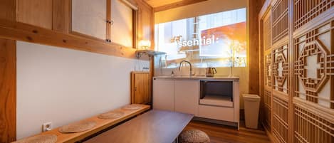 A compact kitchen with a wooden bench, a sink, and a window with a view.