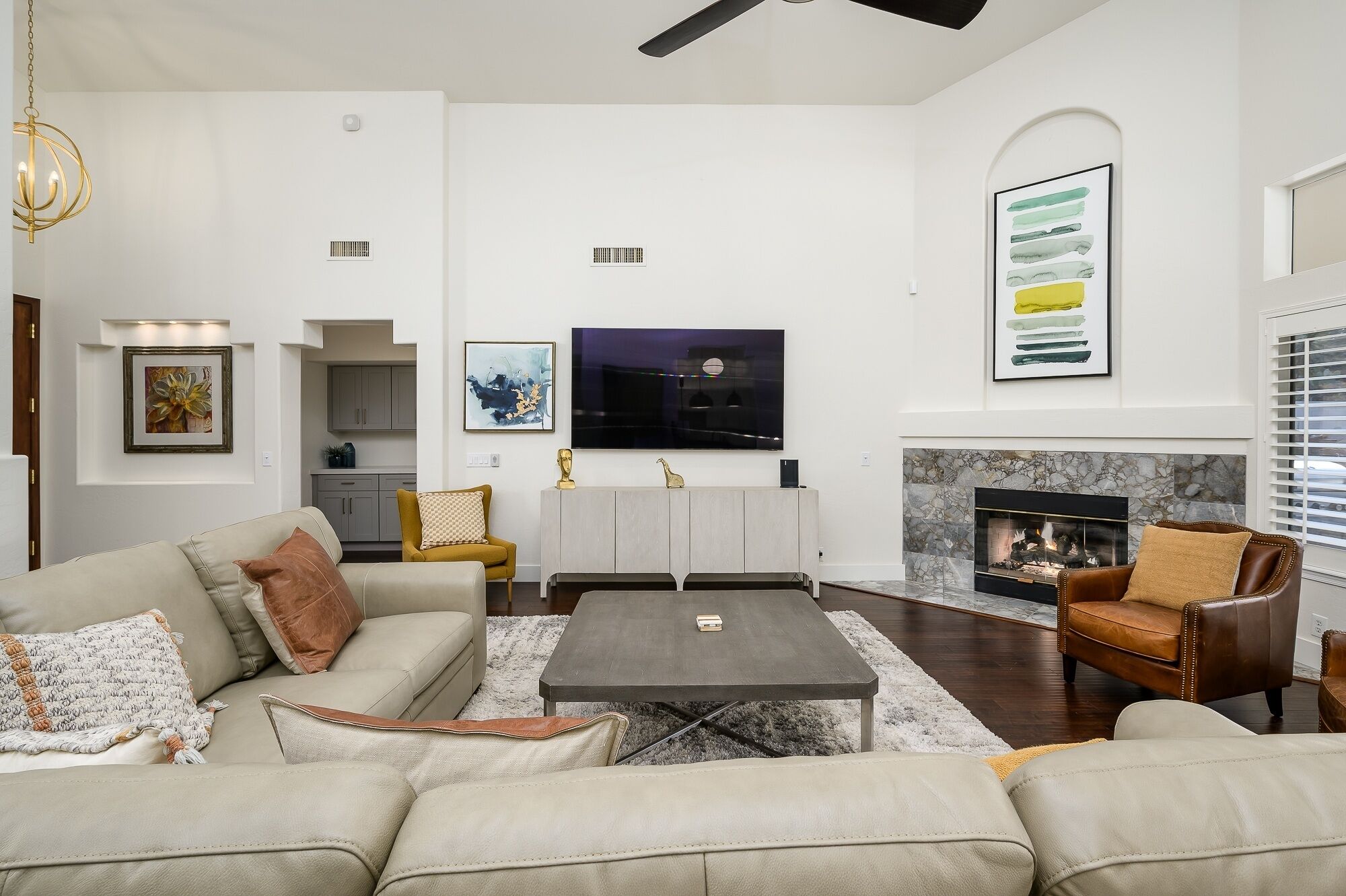 A modern living room with a fireplace, a television, and a dining area.