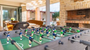 A foosball table in a room with a brick fireplace and a 'Welcome' sign. - Villa Ivan (Novigrad)