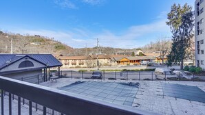 Ein Hotelinnenhof mit eingezäuntem Parkplatz, einem überdachten Sitzbereich und Gebäuden im Hintergrund.