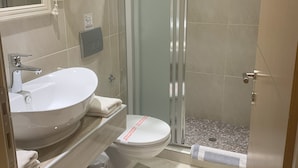 Un bagno con lavandino, WC e doccia.