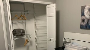A bedroom with a bed, a wardrobe with hanging space, and a painting on the wall. - Your Bright, Confortable, Cozy Second Home

 (Livingston)