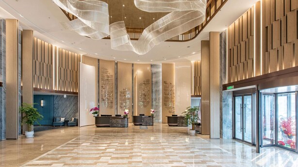 A spacious lobby with a marble floor, reception desks, and a modern ceiling design. - HOJO China Communications Construction Plaza Chongqing (Chongqing)