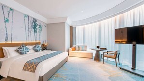 A modern hotel room with a large bed, a sofa, a small table, and a TV. - HOJO China Communications Construction Plaza Chongqing (Chongqing)