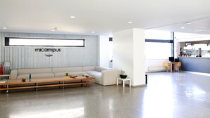 A modern living room with a sofa, coffee table, and a wall-mounted TV. - Micampus Lugo (Lugo)