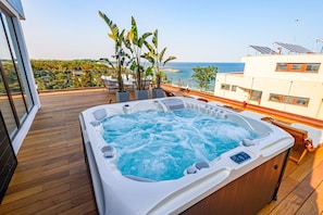 A hot tub on a wooden deck with a view of the sea and greenery. - Vila Time Olimp (Olimp)