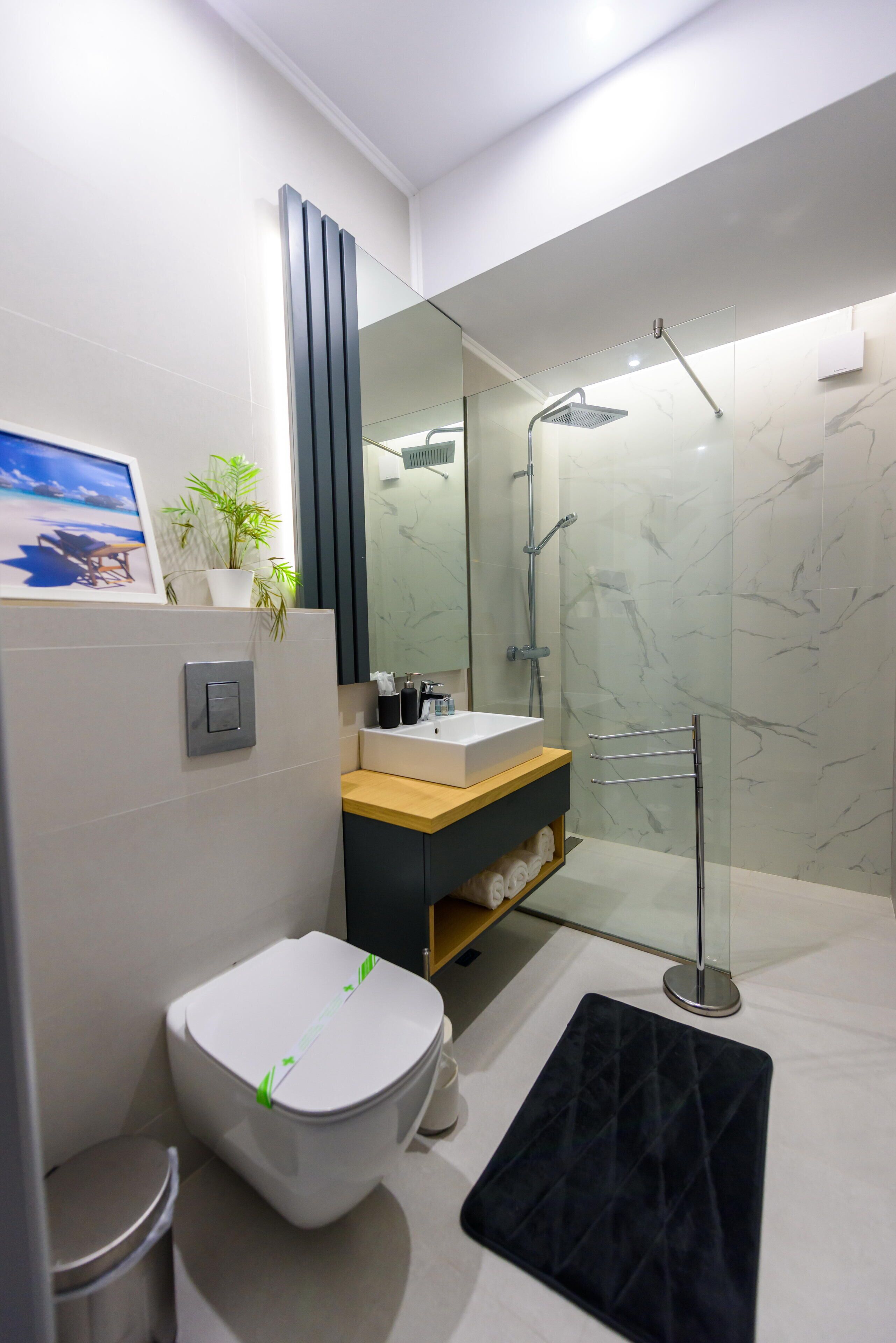 A modern bathroom with a toilet, sink, and shower.