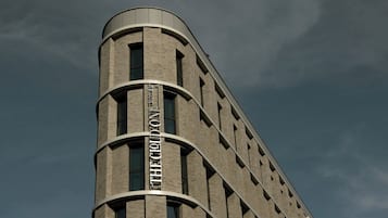 Un bâtiment dont l’angle est incurvé et sur lequel on peut lire l’inscription « HÔTEL ».