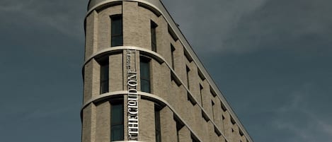 A building with a curved corner and a sign that reads 'HOTEL'.