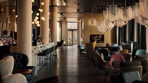 A spacious bar area with multiple seating options and a view of the cityscape. - The Cloud One Prague (Prague)