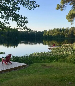 A serene lakeside setting with a dock and a red chair. - Nordic Hideaway on Silverthorn Lake - Little Sisu (Hayward)