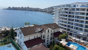 A hotel with a pool, balconies, and a view of the sea.