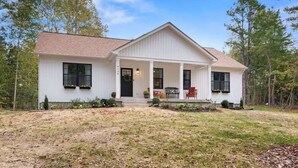 A single-story white house with a front porch, a covered entryway, and a small front yard.