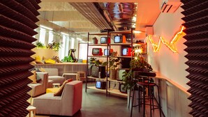 A modern interior with a sofa, chairs, a TV, and a wall with a light design. - Micampus Covilhã (Covilhã)