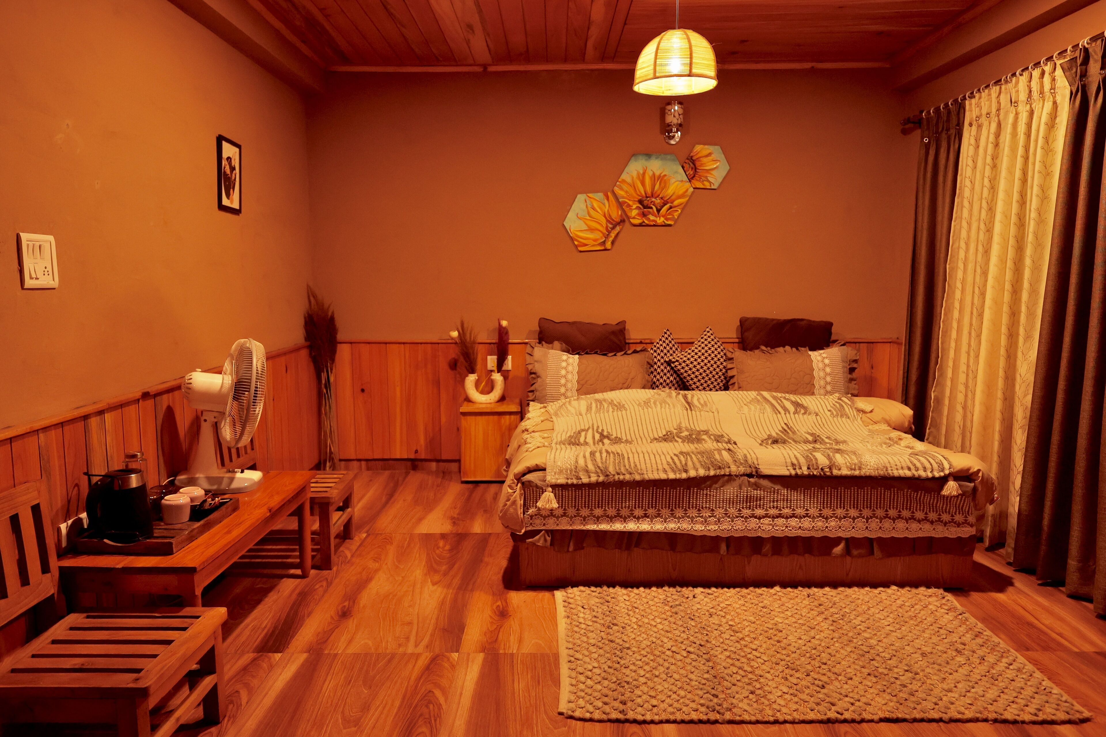 Un dormitorio acogedor con una cama de madera, una mesita de noche, un ventilador y una alfombra.