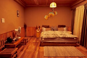 Un dormitorio acogedor con una cama de madera, una mesita de noche, un ventilador y una alfombra.