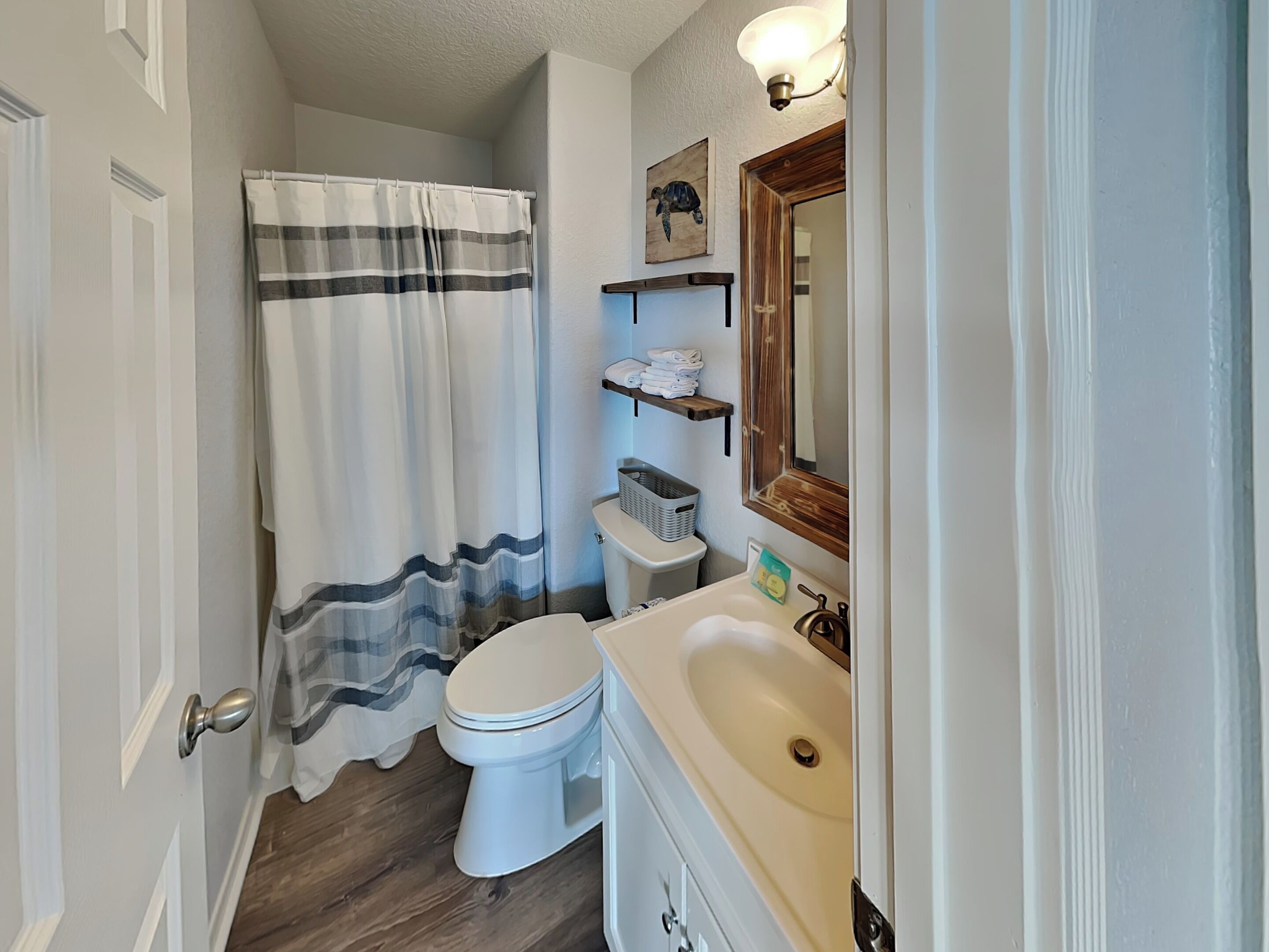 A bathroom with a toilet, sink, and shower curtain.