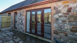 A stone building with a tiled roof, wooden doors, and a stone wall. - The Old Well Bungalow - Ty Mawr Farm (Cardiff)