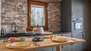 A kitchen with a stone backsplash, a window, a stove, and a refrigerator. - A lovely flat right in the centre of Chamonix (Chamonix-Mont-Blanc)