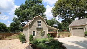 Une maison de plain-pied avec un toit à pignon, une véranda à l’avant et un garage.