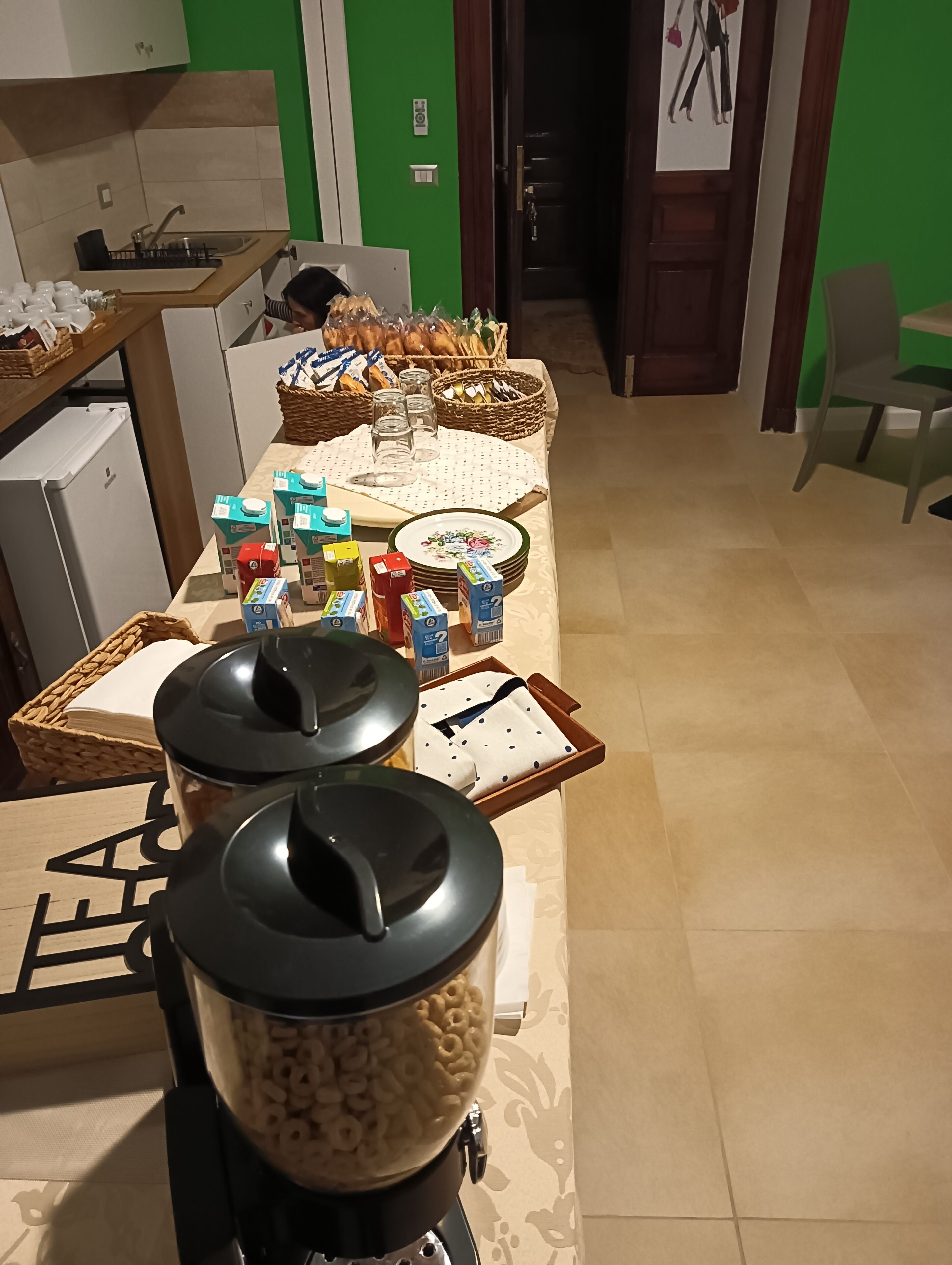 Een ontbijtopstelling met ontbijlgranen, melkpakken en broodbaskets op een tafel.