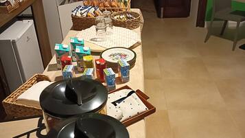 Een ontbijtopstelling met ontbijlgranen, melkpakken en broodbaskets op een tafel.