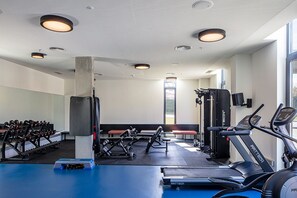 A gym with cardio equipment, weight machines, and dumbbells. - Micampus Porto Asprela (Porto)
